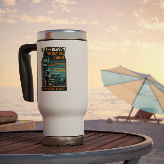 White travel mug with a graphic design on a beach table with an umbrella in the background